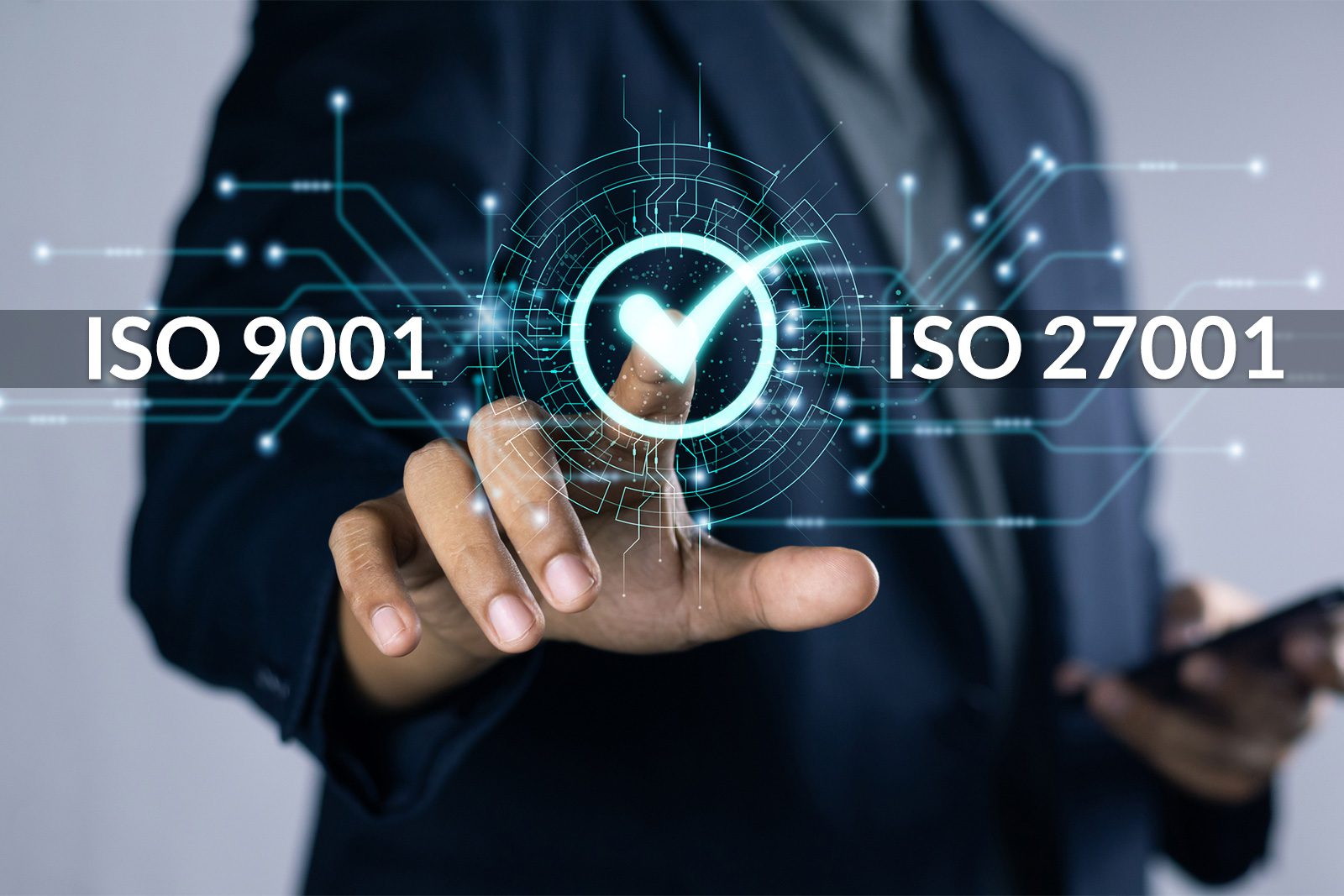 A person in a suit touches a digital interface displaying ISO 9001 and ISO 27001 with a check mark symbol in the center.